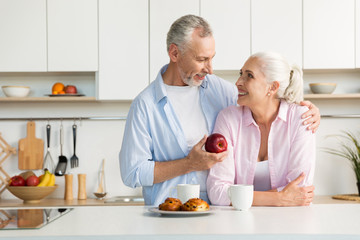 Fototapeta na wymiar Smiling mature loving couple family standing at the kitchen