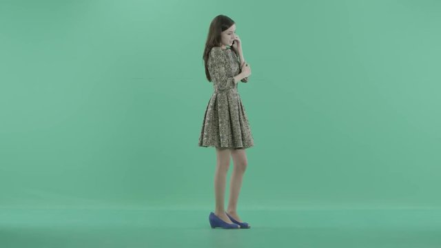 a cute girl in dress talks on the phone