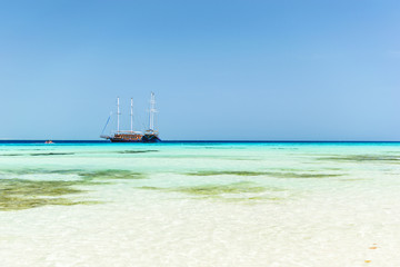 Sailing boat at the red sea. Shallow shore with white sand