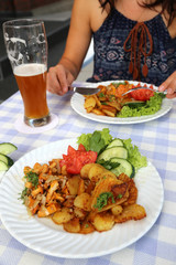 Frau isst im Restaurant ein Gericht mit Pfifferlingen  im Sommer 