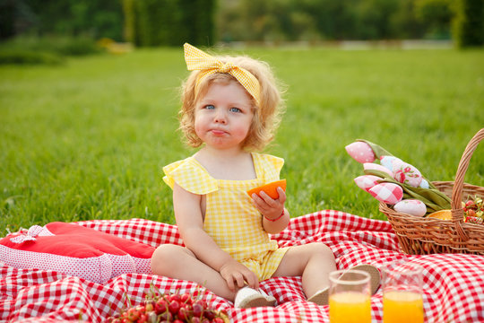 Young Girl Sitting On Blanket In Park