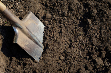 Old rusty shovel in the ground on the building