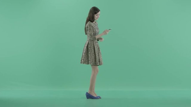 a nice girl is standing with a phone in hands