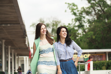 Fototapeta premium Two happy women walking in the summer park