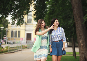 Fototapeta premium Two happy women walking in the summer park