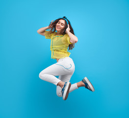 Brunette girl enjoying music in mid-air