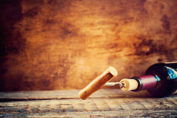 Bottle Wine with Corkscrew on Wooden Background
