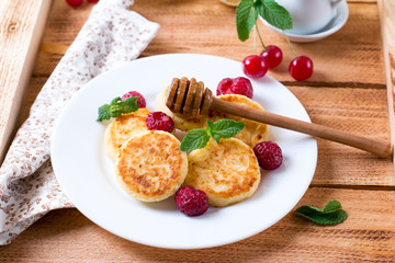 Cottage cheese pancakes with honey on background