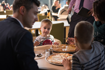 Young parents enjoying lunch time with their children