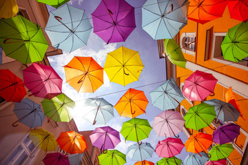 Colorful background of open umbrellas hanging in the air.