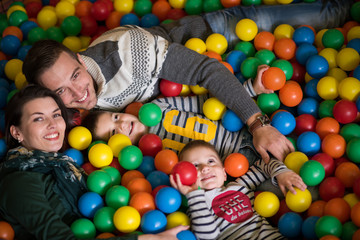 Fototapeta na wymiar young parents with kids in a children's playroom