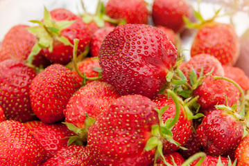 Ripe, juicy red strawberries, on blurred background taken close-up, selective focus.
