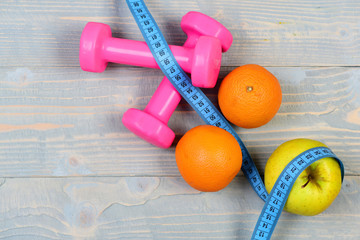 fruits with dumbbells weight and measuring tape on blue vintage