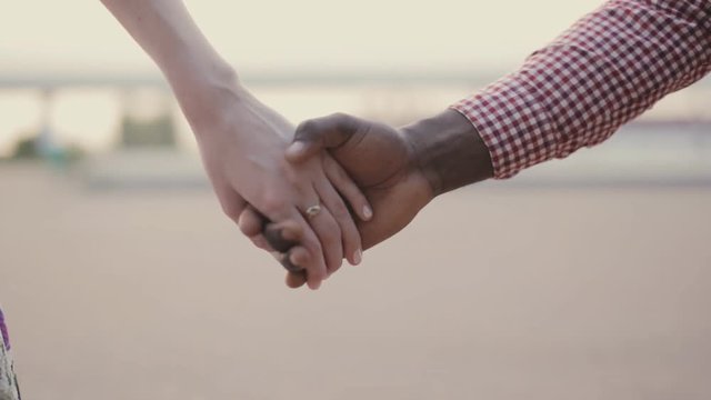 two interracial lovers joining hands
