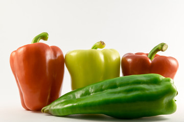 colored peppers over white background