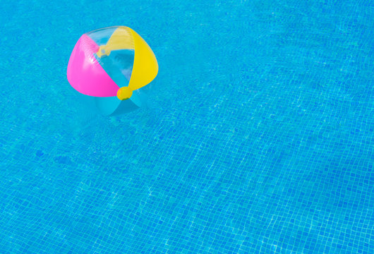 Beach ball in swimming pool water
