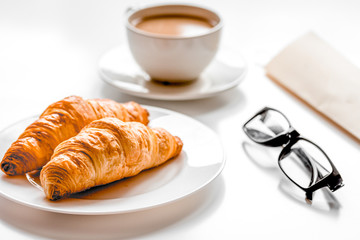 Breakfast for businessman with coffee and croissant on white tab