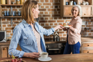 two women, senior and young having good time in kitchen