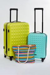 Two suitcases and bright handbag. Fashionable bags for holiday abroad.