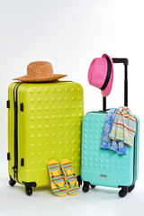 Colorful summer clothes and suitcases. Bright elements of summer holiday.