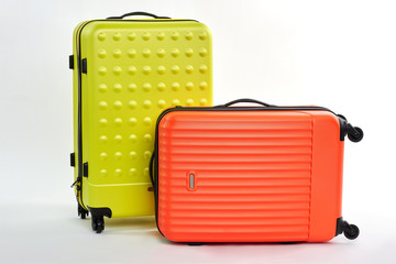 Pair of colorful suitcases. Red and yellow bags on wheels, white background.