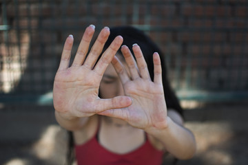 Chica con manos protegiendo