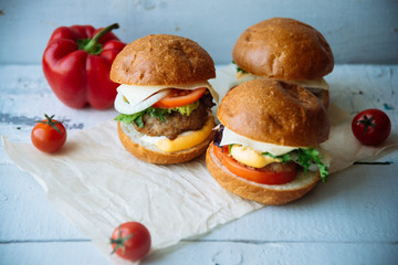The traditional hamburger Patty, cheese, tomato, lettuce, beef Burger, takeaway. Dark wooden background, horizontal shot.
