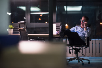 businessman using mobile phone in dark office