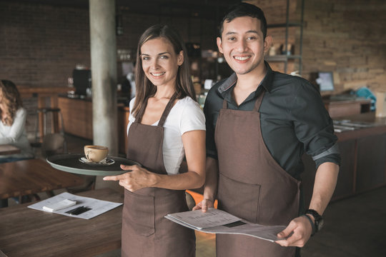 two waitress smiling to camera in the cafe
