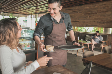 waitress serving coffee to a customer