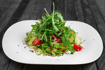 Salad of fresh avocado, cucumber, tomato cherry,  cabbage, lettuce and pumpkin seed sparged with vinegar