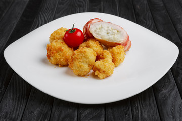 Feta cheese wrapped by bacon and fried in oil with potato in breading