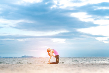 Obraz premium Young asian yoga exercise with posting on the beach in summer outdoor