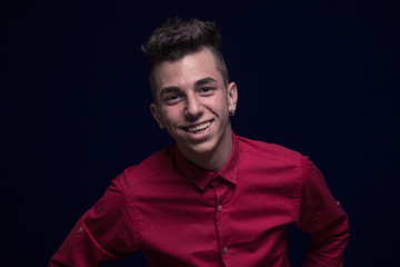 one teenager boy, red shirt, Caucasian, dark background, looking to camera, smiling