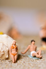 miniature people in swimsuit on the beach