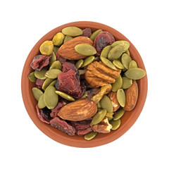 Top view of Omega 3 trail mix in an small clay bowl isolated on a white background.