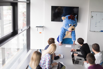 boss dresed as bear having fun with business people in trendy office