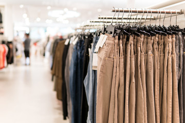 Hanger of beige jeans at Fashion clothing store.
