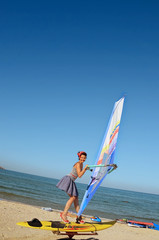 Naklejka premium A girl at a windsurfing school learns to ride a windsurf board. Sea. Pin an.