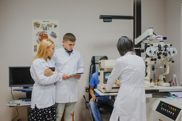 Eye Doctor/optometrist/ophthalmologist examining a young patient and explain to the students