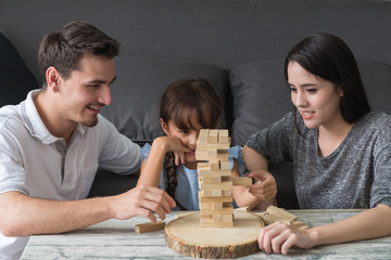 happy family and Daughter playing the wooden blocks tower at home