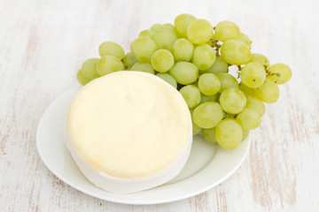 cheese with green grapes on white dish