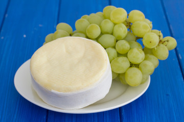 cheese with green grapes on white dish