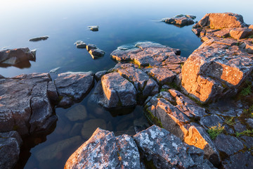 Rocks of stony coast in calm water