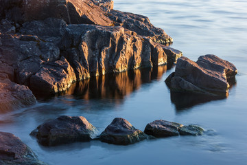 Rocks of stony coast in lake water