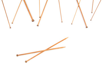 Variety of wooden knitting needles in different sizes on white background