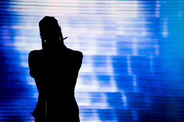 Silhouette of an artist singing live on the stage