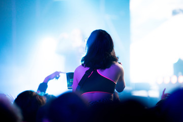 Silhouette of concert crowd in front of bright stage lights