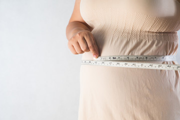 fat woman measuring her stomach