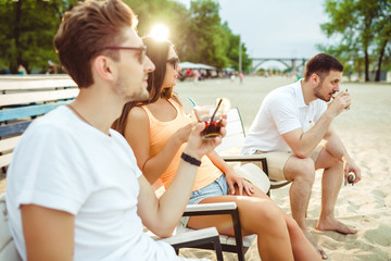 Young people enjoying summer vacation sunbathing drinking at beach bar